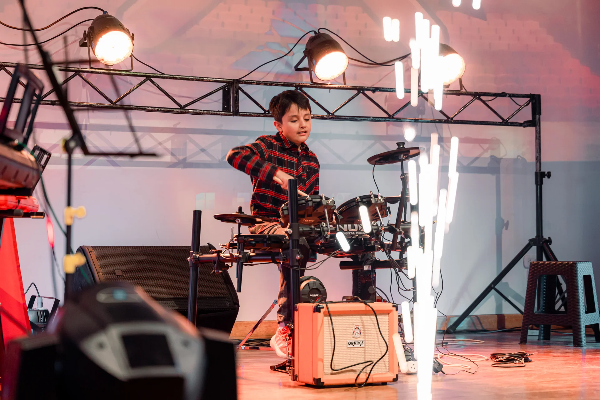 Alumno de Musiqué tocando batería en presentación